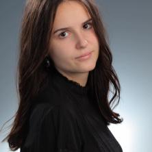 headshot of woman with brown hair and black shirt