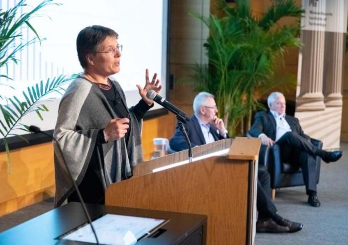 Susanne Moser, director of Susanne Moser Research and Consulting, addresses MIT’s second Symposium on Climate Change. In the background are Andrew Steer, president and CEO of the World Resources Institute, and Richard Schmalensee, the Howard W...