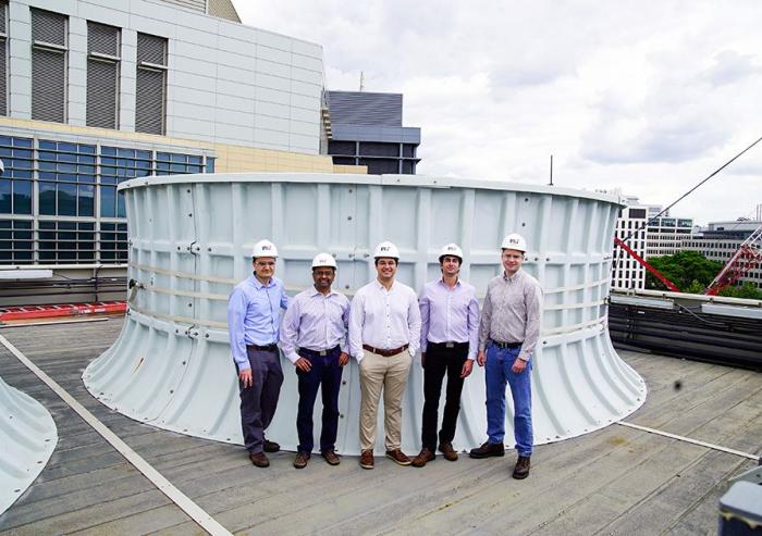 On the roof of the Central Utility Plant building, standing in front of one of the cooling towers, are (left to right): Seth Kinderman, Central Utility Plant engineering manager; Kripa Varanasi, associate professor of mechanical engineering; recen...
