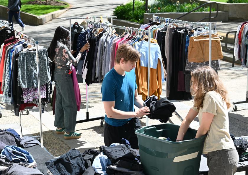 Cameron Dougal (center) helps a customer at an Infinite Threads popup sale. “Our goal is simple,” says Dougal. “We want to keep clothing out of landfills, which in return helps the planet.”