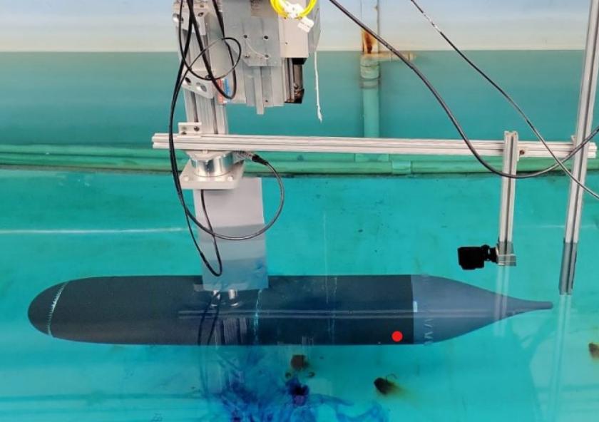 Initial experimental setup, showing the submerged axisymmetric model rigidly attached at about mid-length to the towing carriage through a streamlined strut.