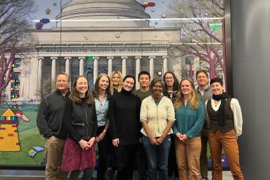 MITOS staff plus visitors in front of MIT Dome art in Welcome Center