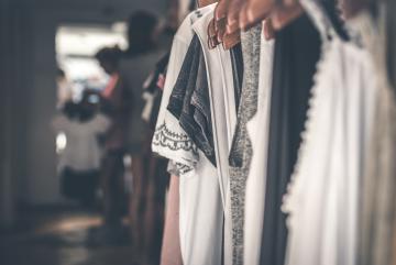 assorted clothing hangs on a rack