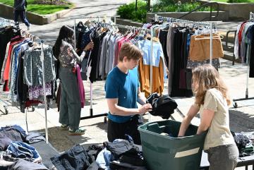 Cameron Dougal (center) helps a customer at an Infinite Threads popup sale. “Our goal is simple,” says Dougal. “We want to keep clothing out of landfills, which in return helps the planet.”