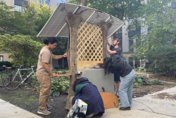 NEET scholars install their team's solar-powered charging station in an MIT campus courtyard as part of 22.03/3.0061 (Introduction to Design Thinking and Rapid Prototyping), a class offered through the NEET Climate and Sustainability Systems thread.