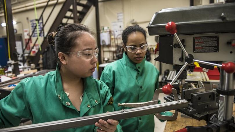 two women using a machine in a lab