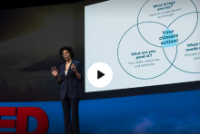 a woman stands on stage to give a ted talk