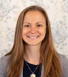 headshot of woman with brown hair and suit coat