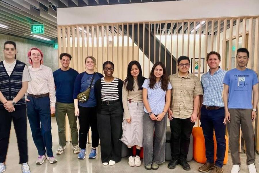 A group of students standing together smiling in the Office of Sustainability