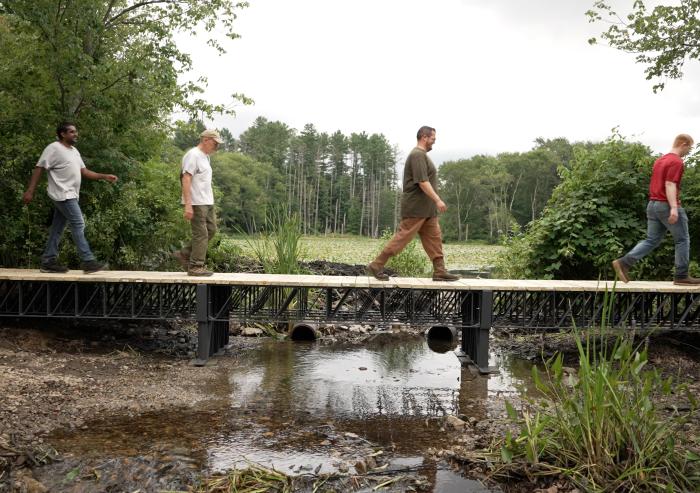 Atlas Building Composites, an MIT spinout, recently supplied the U.S. Army Corps of Engineers with American-made recycled composite trusses to construct a 40-foot bridge in a Massachusetts wetland, pictured.