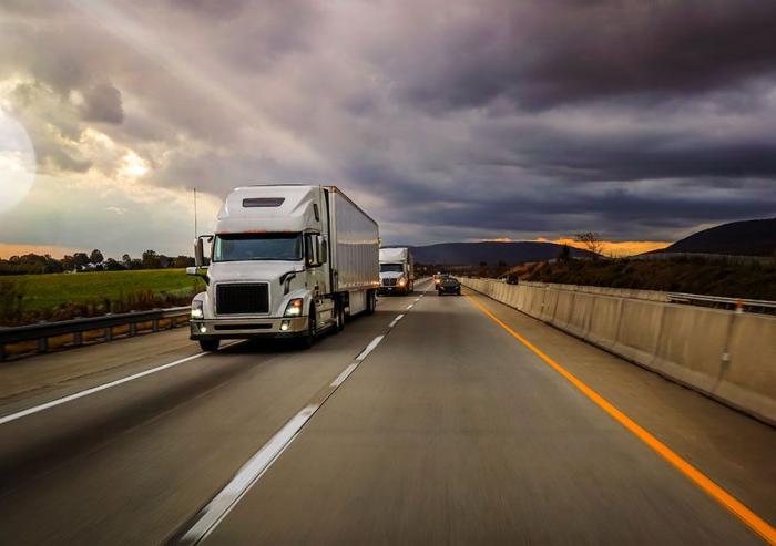 Heavy trucks such as these 18-wheelers contribute a significant fraction of the world’s greenhouse gas emissions. MIT researchers say these emissions could be drastically reduced by using flex-fuel plug-in hybrid powertrains instead of diesel engines.