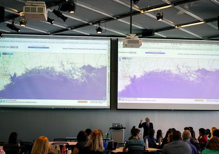 Professor John Sterman displays maps showing the consequences of sea-level rise on various coastal cities, as part of the “SimPlanet” event at MIT.Images: Melanie Gonick, MIT