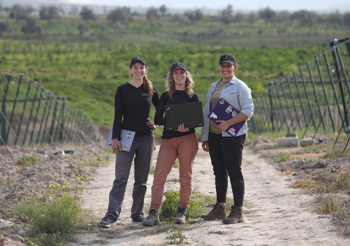 
              Global Engineering and Research (GEAR) Lab students (from left to right) Georgia Van de Zande, Carolyn Sheline, and Fiona Grant pilot a low-cost precision irrigation controller that optimizes system energy and water use at ...