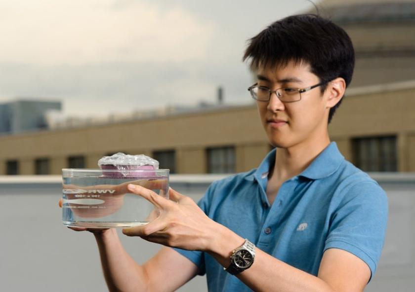 MIT graduate student George Ni holds a bubble-wrapped, sponge-like device that soaks up natural sunlight and heats water to boiling temperatures, generating steam through its pores.