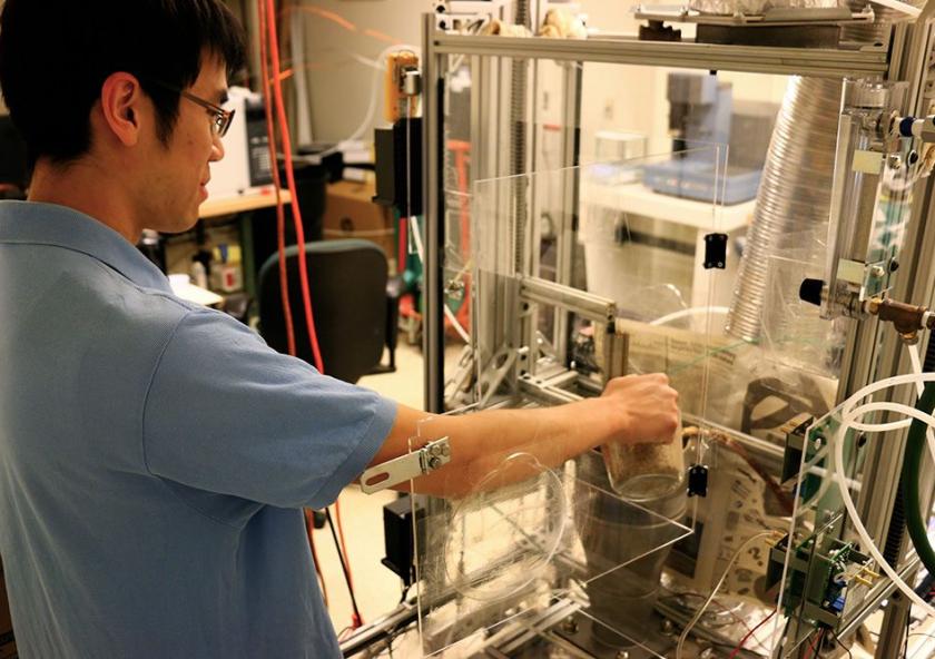 Kevin Kung, a Tata Fellow and PhD candidate in biological engineering, feeds rice husks into the torrefaction reactor in his lab at MIT. A thermochemical process will convert the biomass to a more energy-dense form, making it easier to transport an...