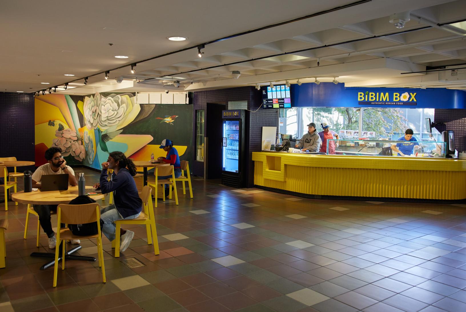 students sit around a table in a dining area