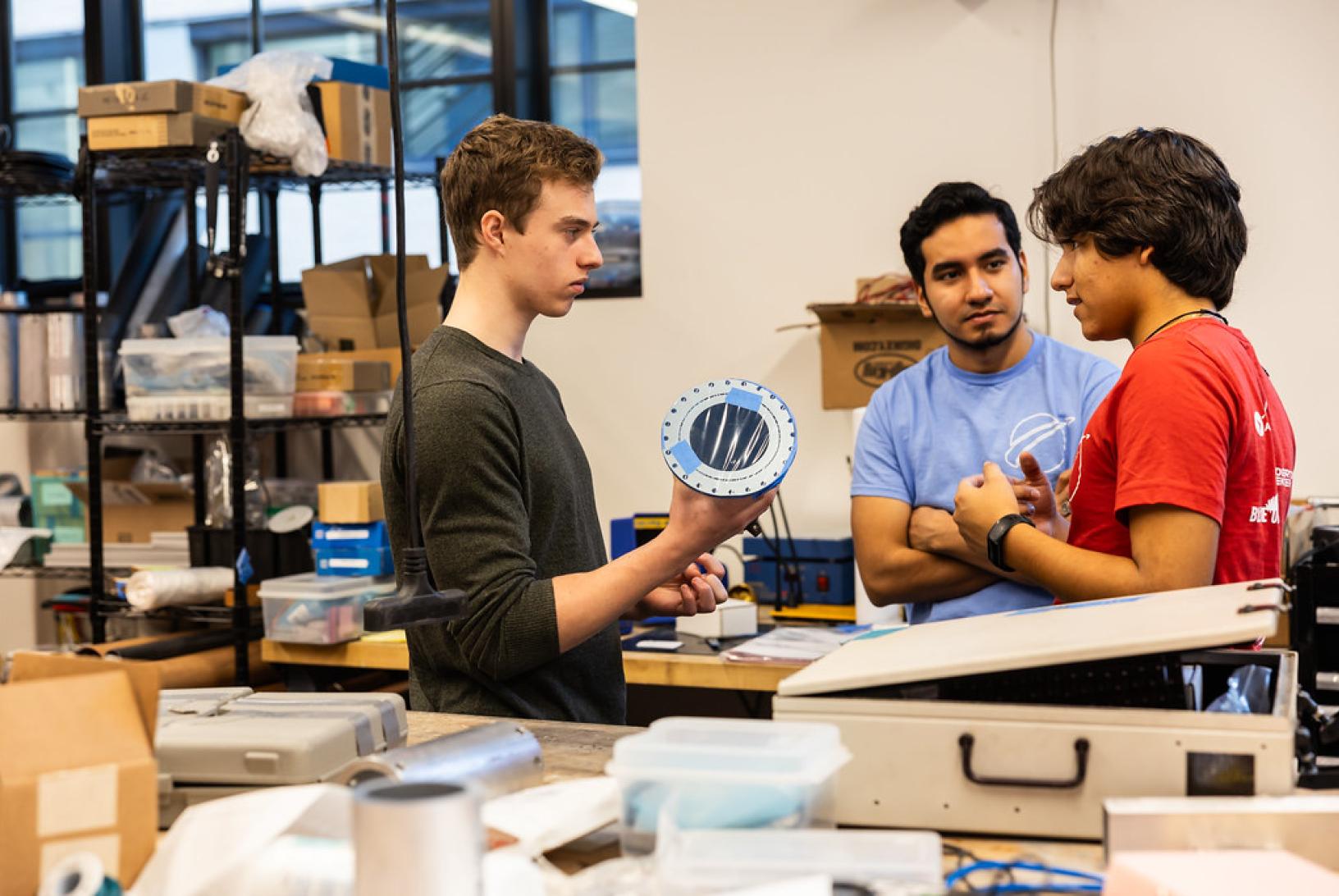 three men working at a project table in aero astro lab