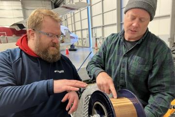 
              Lincoln Laboratory’s Ben Evans (left) and Dave Whelihan deployed this spool — featuring 230 feet of polymer fiber with embedded temperature and depth sensors — in the Arctic. 
              Photo: Seth Koenig/U.S. Navy
      