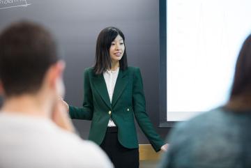 Jing Li, an assistant professor of applied economics, engages with her students during the Electricity Strategy Game debrief.Photo: Kelley Travers
