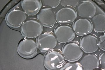 
              MIT engineers have synthesized a superabsorbent material that can soak up a record amount of moisture from the air, even in desert-like conditions. Pictured are the hydrogel discs swollen in water.
              Image: Gustav Graebe...