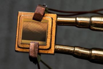 
              A thermophotovoltaic (TPV) cell (size 1 cm x 1 cm) mounted on a heat sink designed to measure the TPV cell efficiency. To measure the efficiency, the cell is exposed to an emitter and simultaneous measurements of electric power an...