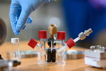 An H-cell modified with electrodes and an ion-conducting ceramic membrane to conduct sodium-air fuel cell experiments.