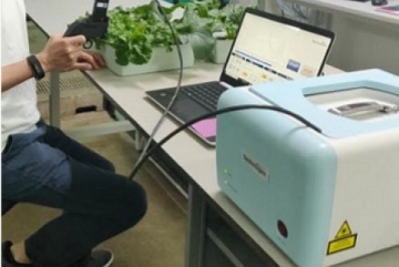 
              A portable leaf-clip Raman sensor in use at Temasek Life Sciences Laboratory detects nutrient stress in leafy vegetables.
          