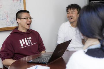 Graduate student Tianli Zhou (left) during a lab meeting. Zhou is studying how to make transportation systems more efficient, particularly through vehicle-sharing services.Photo: Alan Silfen
