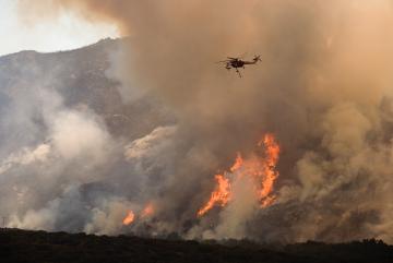 
              Helicopters drop water and fire retardant on a wildfire in Southern California. 
              Photo: Andrea Booher/FEMA
      