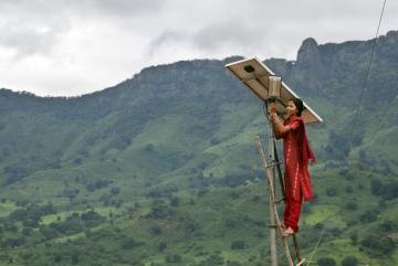 
              A solar engineer maintains the street lighting in her village of Tinginaput, India — a rural area not connected to the region’s main electrical grid. 
              Photo: Abbie Trayler-Smith/Panos Pictures
      
