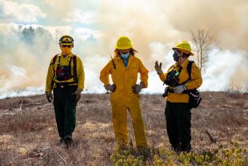 
              Kathleen Theoharides (center) oversees the Commonwealth’s six environmental, natural resource, and energy regulatory agencies. In this role, the secretary joined MassWildlife for a prescribed burn on April 8 at the Birch Hil...