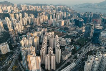 A dense high-rise development in Kowloon, Hong Kong, reflects the speed and scale of urbanization across Asia, where cities are expanding rapidly to accommodate growing populations.