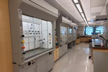 
              Fume hoods like these are placed into hibernation mode when they are no longer in use for the day. Since employing the use of hibernation mode, the unoccupied Undergraduate Teaching Lab air change rate has plummeted from 11 ai...