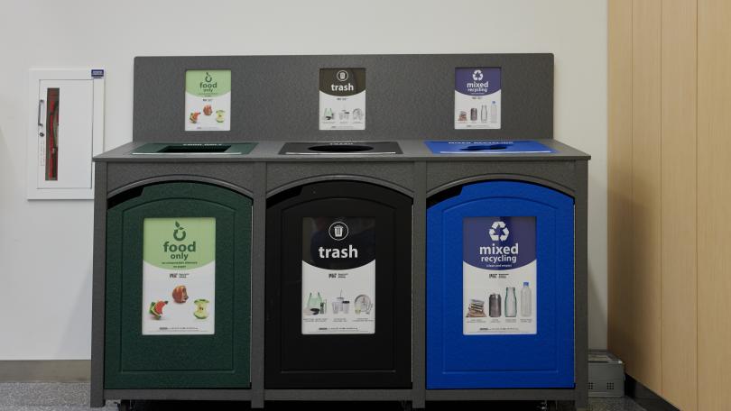 a three bin station with food waste, trash, and recycling bins